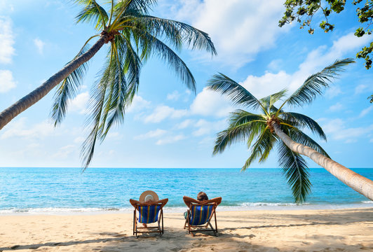 Couple Relax On The Beach Enjoying Beautiful Sea On The Tropical Island