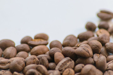 Ganze Kaffeebohnen vor neutralem Hintergrund symbolisieren Kaffeegenuss für echte Kaffeeliebhaber