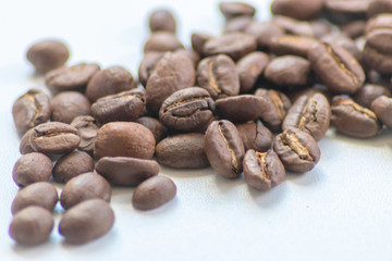 Ganze Kaffeebohnen vor neutralem Hintergrund symbolisieren Kaffeegenuss für echte Kaffeeliebhaber
