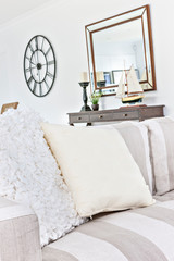 White pillows on chair near mirror and table.