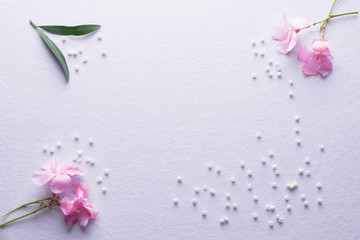 Pink vlower, green leaves and white beads on a bright pink/purple background. Love concept with copy-space for text.