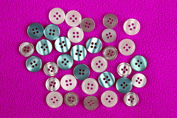 Fototapeta premium different mother of pearl buttons on a pink cloth.