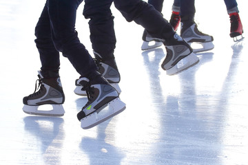 Obraz premium feet of different people skating on the ice rink