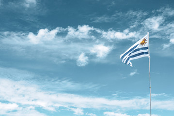 Uruguay flag fluctuation on the cloudy sky