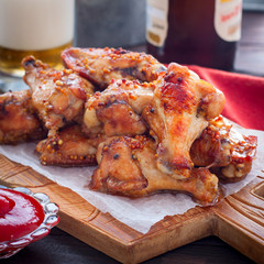 Baked Buffalo Beer Wings on a wooden board, square