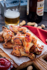 Baked beer wings on a wooden board, selective focus