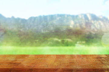 Wood table top on blur mountains background. Nature concept of landscape. Empty brown wooden table on natural background for montage product display or design key visual layout.