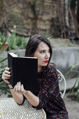 Obraz premium Girl reading a book in a cafeteria