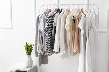 Rack with clean female clothes in dressing room