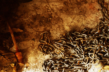 Old rusty chain lies on the dirty floor. Grunge style. Free place.