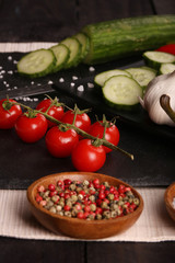 Healthy food. Vegetables on a black plate and stone cutting board and wooden background.