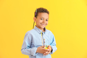 Cute little African-American artist on color background
