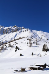 Fototapeta na wymiar Snow-capped mountains in Trentino Alto Adige. Mountains in winter. Winter landscape in the Alps Mountains, Moena, Val di Fassa.