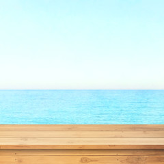 Table top with beach background, sky and cloud in sunny day for product display job showing. Wooden table for display or montage your products.
