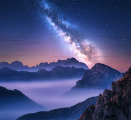 Fototapeta na wymiar Milky Way over mountains in fog at night in summer