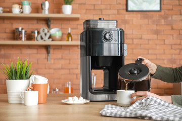 Beautiful woman using coffee machine in kitchen