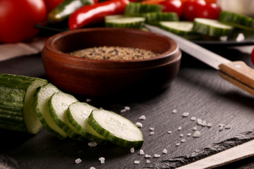 Healthy food. Vegetables on a black plate and stone cutting board and wooden background.