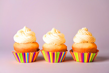Tasty Birthday cupcakes on grey background