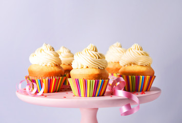 Stand with tasty Birthday cupcakes on grey background
