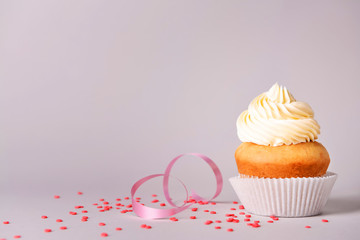 Tasty Birthday cupcake on grey background
