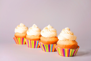 Tasty Birthday cupcakes on grey background