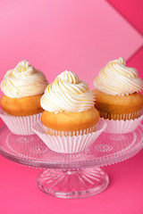Stand with tasty Birthday cupcakes on color background