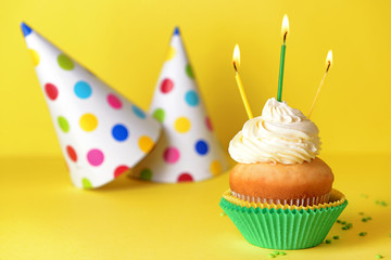 Tasty Birthday cupcake on color background