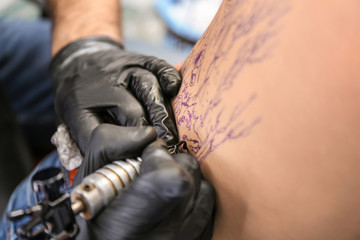 Fototapeta na wymiar Professional artist making tattoo in salon, closeup