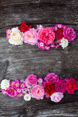 pink,red, violet and white roses on wooden surface