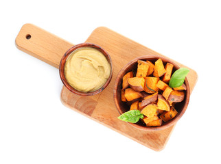 Bowls with tasty cooked sweet potato and sauce on white background
