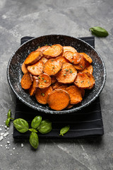 Plate with tasty cooked sweet potato on grey background