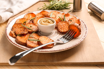 Plate with tasty cooked sweet potato and sauce on table