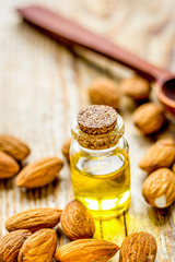 spa with almond oil in organic cosmetic set on wooden background