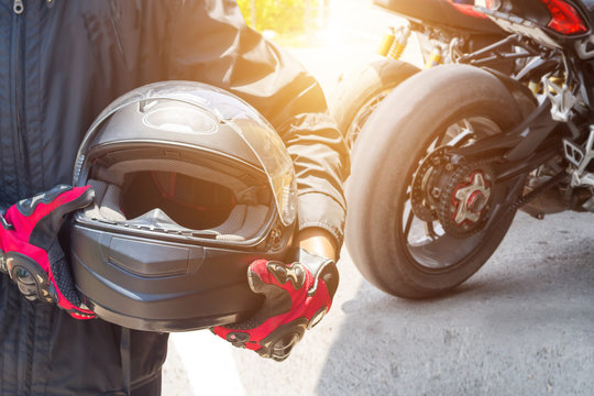 Man In A Motorcycle With Helmet And Gloves Is An Important Protective Clothing For Motorcycling Throttle Control With Sun Light,safety Concept