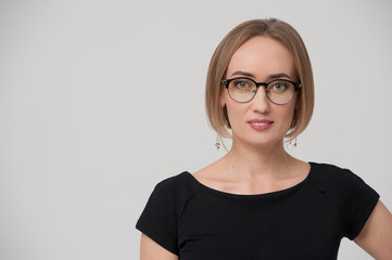 Smiling charming young businesswoman wearing formal suit and stylish glasses