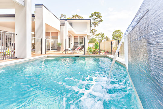 Swimming pool design with water and house garden.