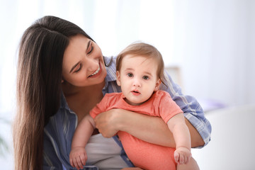 Happy mother with adorable baby boy at home