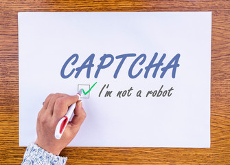 hand writing words CAPTCHA i'm not a robot on paper sheet