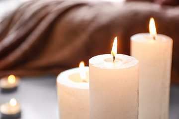 Beautiful burning candles on floor in room, closeup