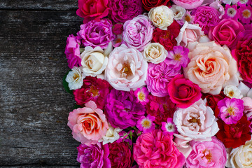 pink,red, violet and white roses on wooden surface