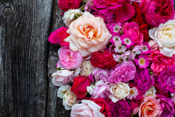 pink,red, violet and white roses on wooden surface