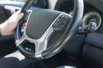 Man driving car, the left hand holding steering wheel
