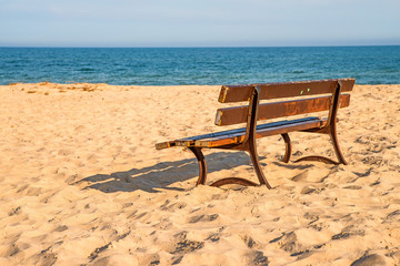 bench on a lonesome beach of the Baltic Sea with blue sky