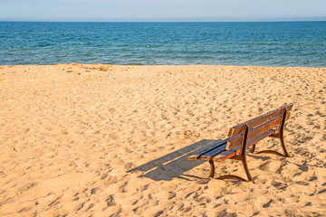 bench on a lonesome beach of the Baltic Sea with blue sky