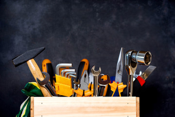 construction tools in wooden box in black background