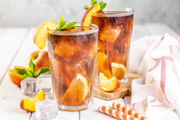 Iced tea and ingredients in glasses on wood background, copy space