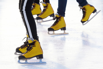 feet of different people skating on the ice rink. sports, Hobbies and recreation of active people.