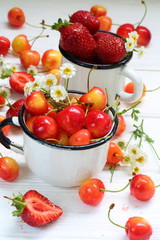Sweet cherry, strawberry and strawberry smoothies on a white wooden background