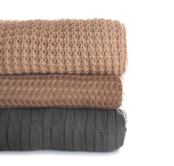 Stack of warm clothes on white background