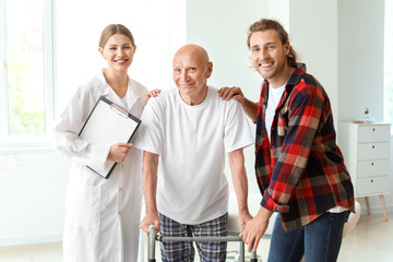Young man visiting his elderly father in modern clinic